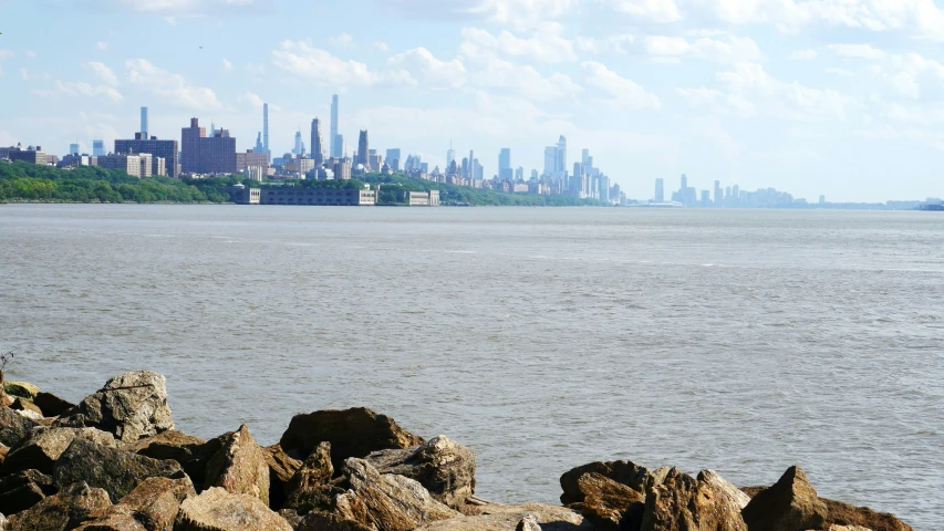 a view from a rocky shore looking at the city