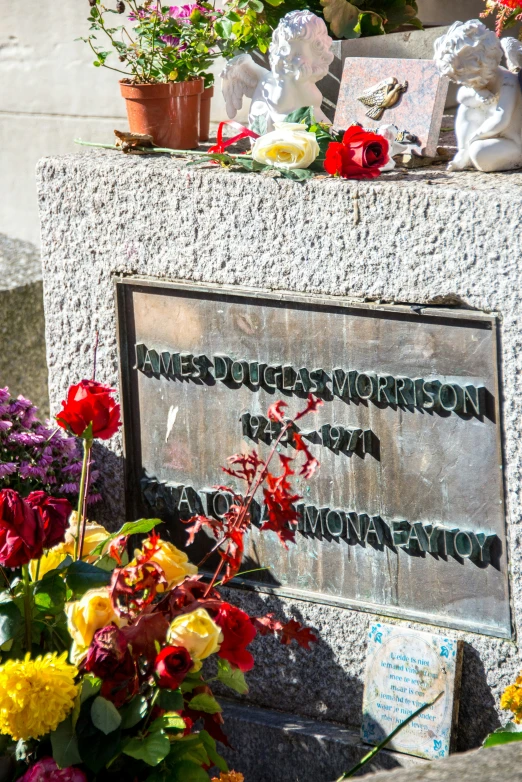 a grave with flowers and pictures on the back