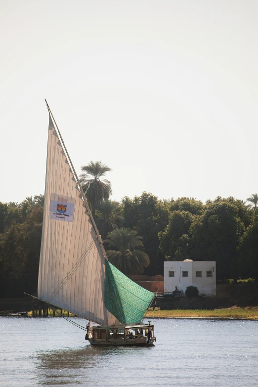 a sailboat with people is sailing on the water