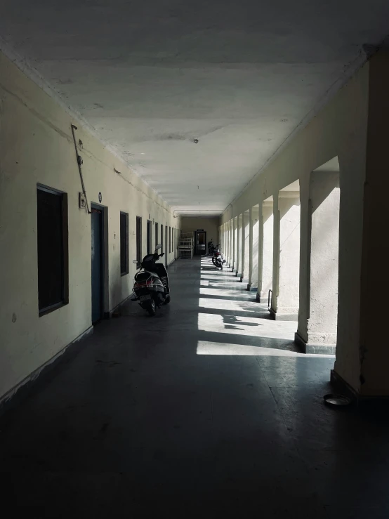 a long hallway has many parked motorcycles along it