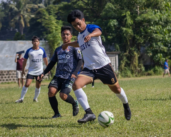 two boys playing a soccer game, one wearing black and white