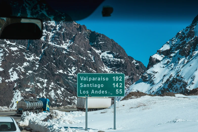 a green sign pointing in to santiago's on a road