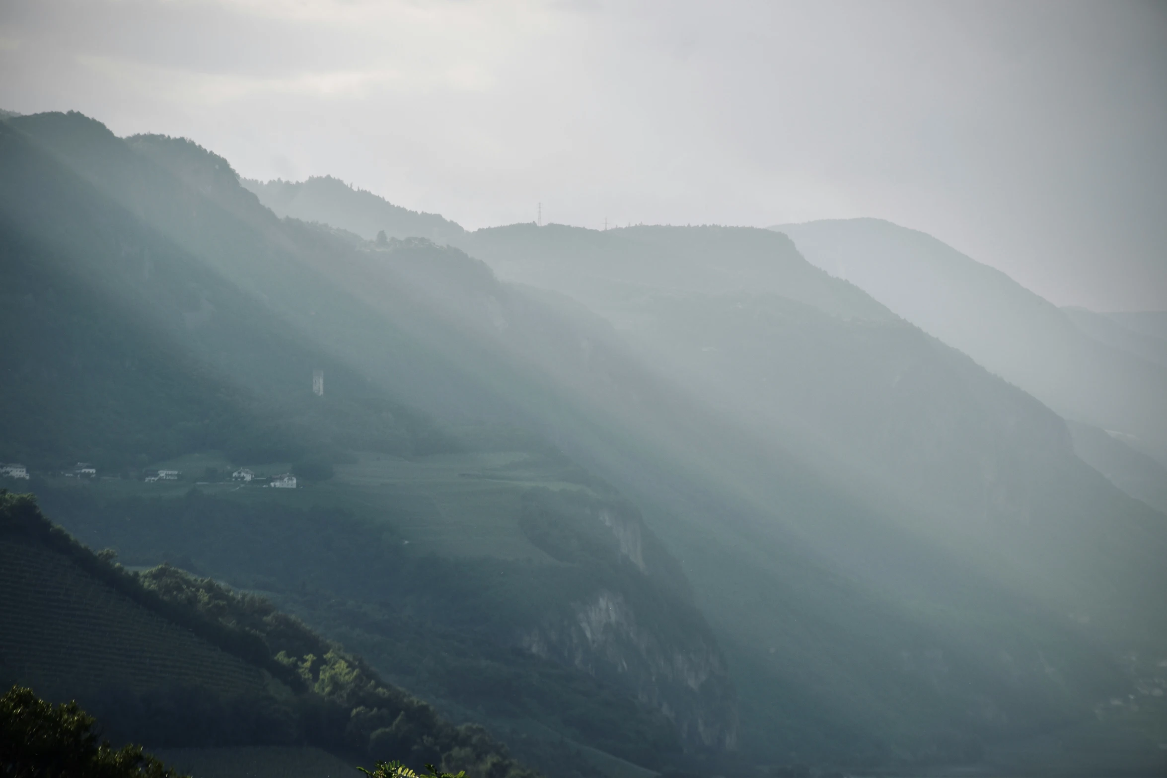 an airplane flying in the cloudy mountains on a rainy day