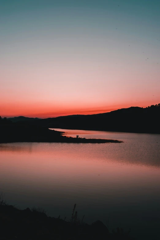 a bright sunset at an overlook overlooking a lake