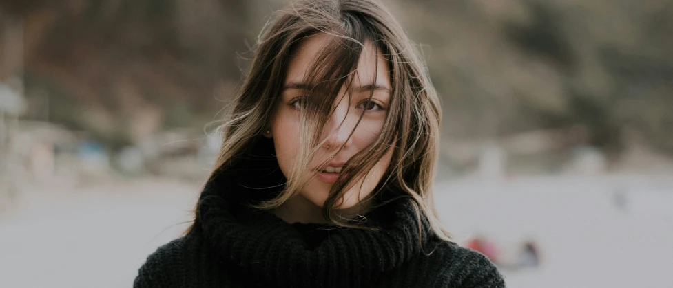 young woman with hair blowing back on the beach