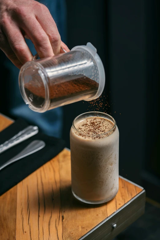 a person pours brown liquid from a coffee cup