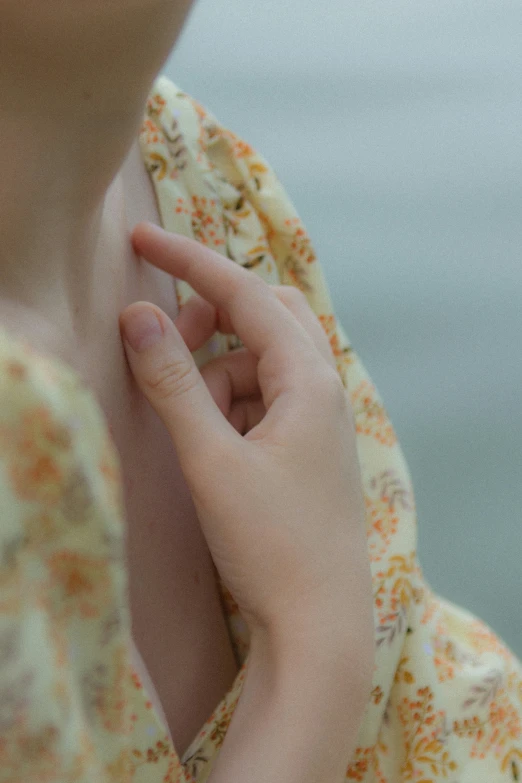 a woman has her hand on the front of her neck