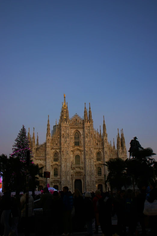 an image of a castle at night with a lot of people outside