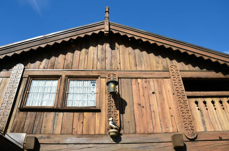 two windows on the side of a wooden building