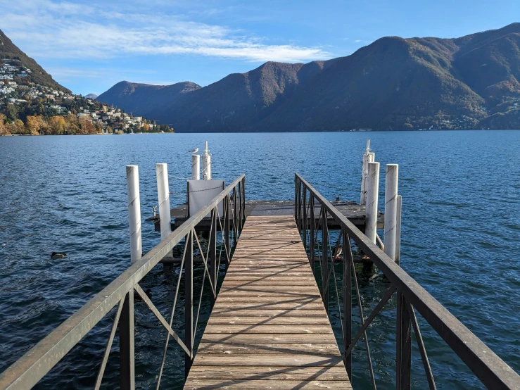 a long dock with mountains on a mountain lake