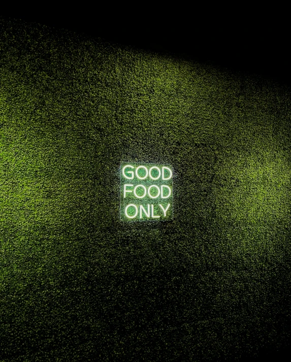 a green wall that has a neon sign in the middle of it