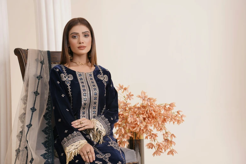 a woman in indian traditional clothing sits down wearing her handbag