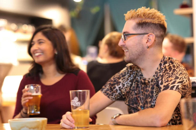 two women smiling with one holding a glass of beer