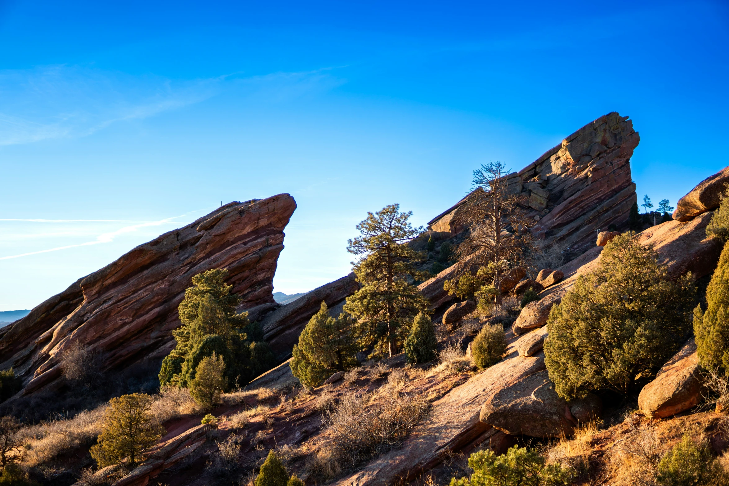 a person riding on a horse next to tall rocks