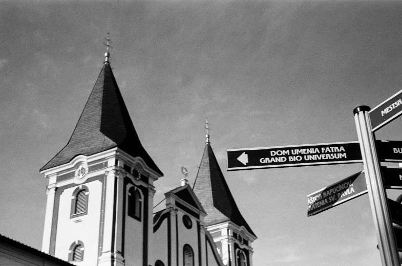 this is an image of street signs with an old church in the background