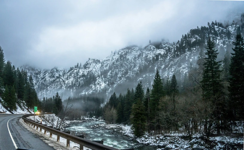 a long road surrounded by snow and some trees