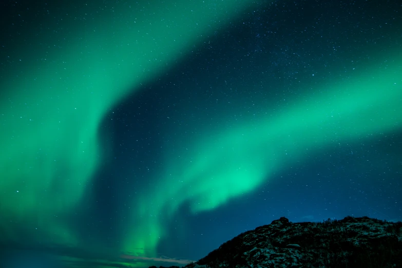 a dark sky night with green light from aurora