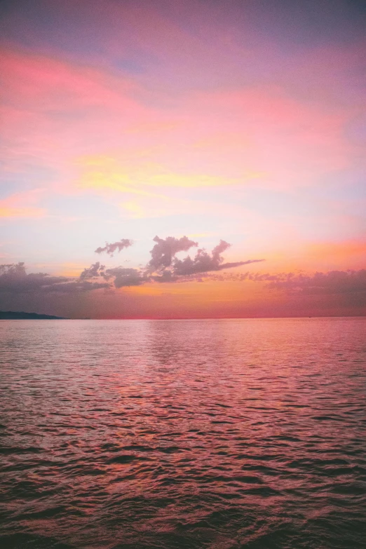 the beautiful pink sunset lights up the skies over the ocean