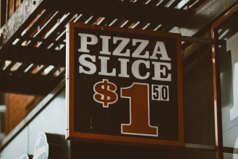 a sign for the pizza slice store is displayed for the camera