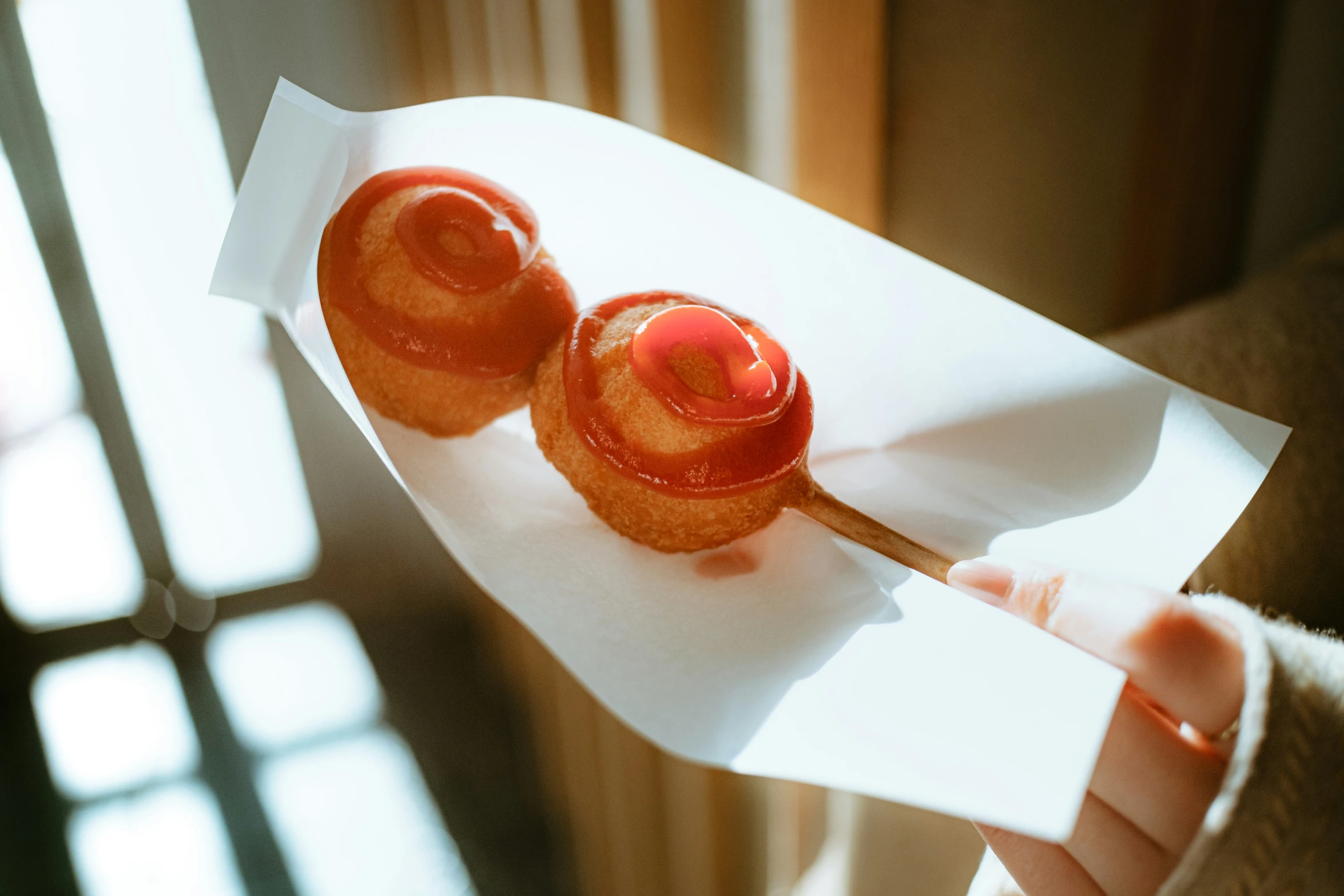 small donuts on stick sitting in white envelope