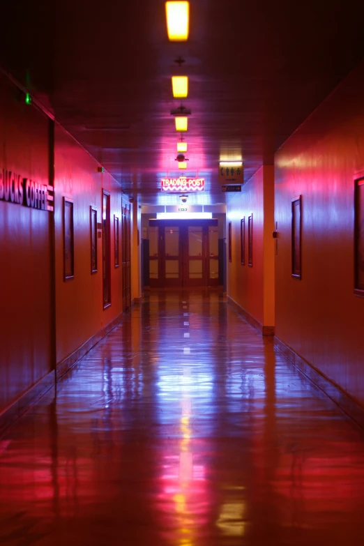 the hallway of a building with lights on and signs lit up