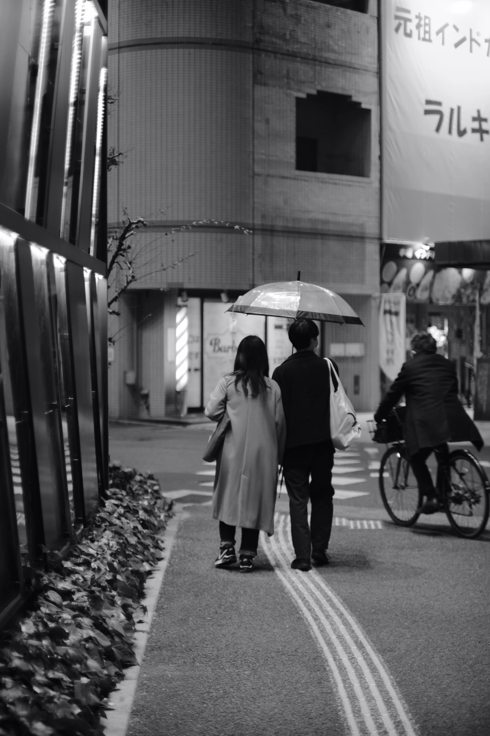 a man and woman walking in the rain holding an umbrella