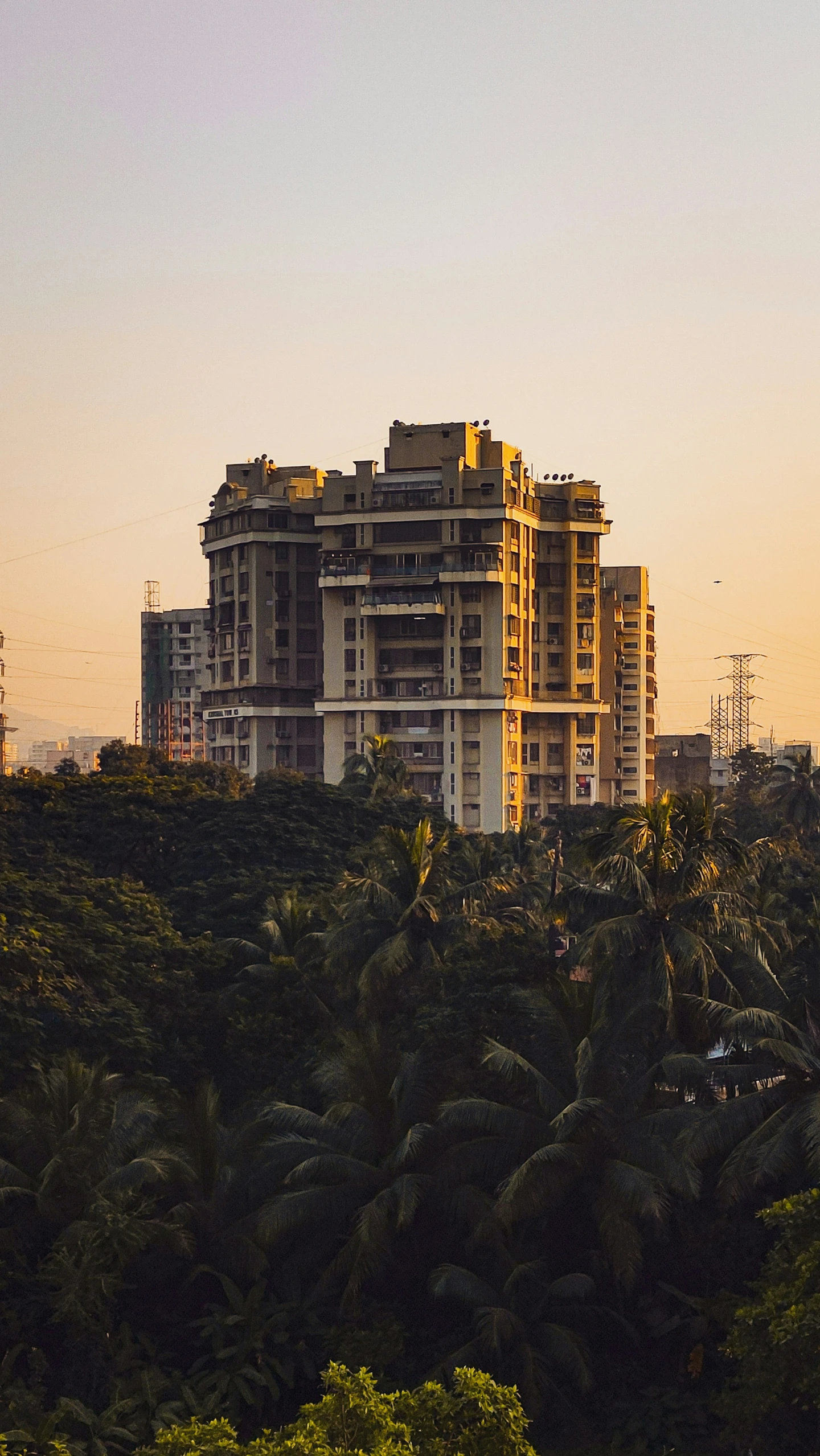 large residential buildings are near a hill that extends from a town