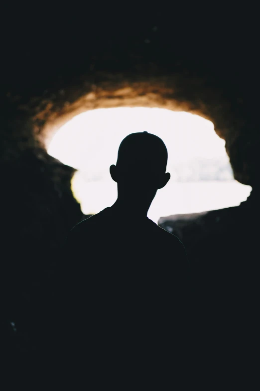 man in silhouette at night standing in cave