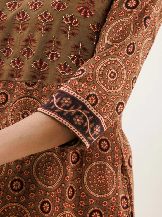a woman's arm wrapped around a paisley print dress