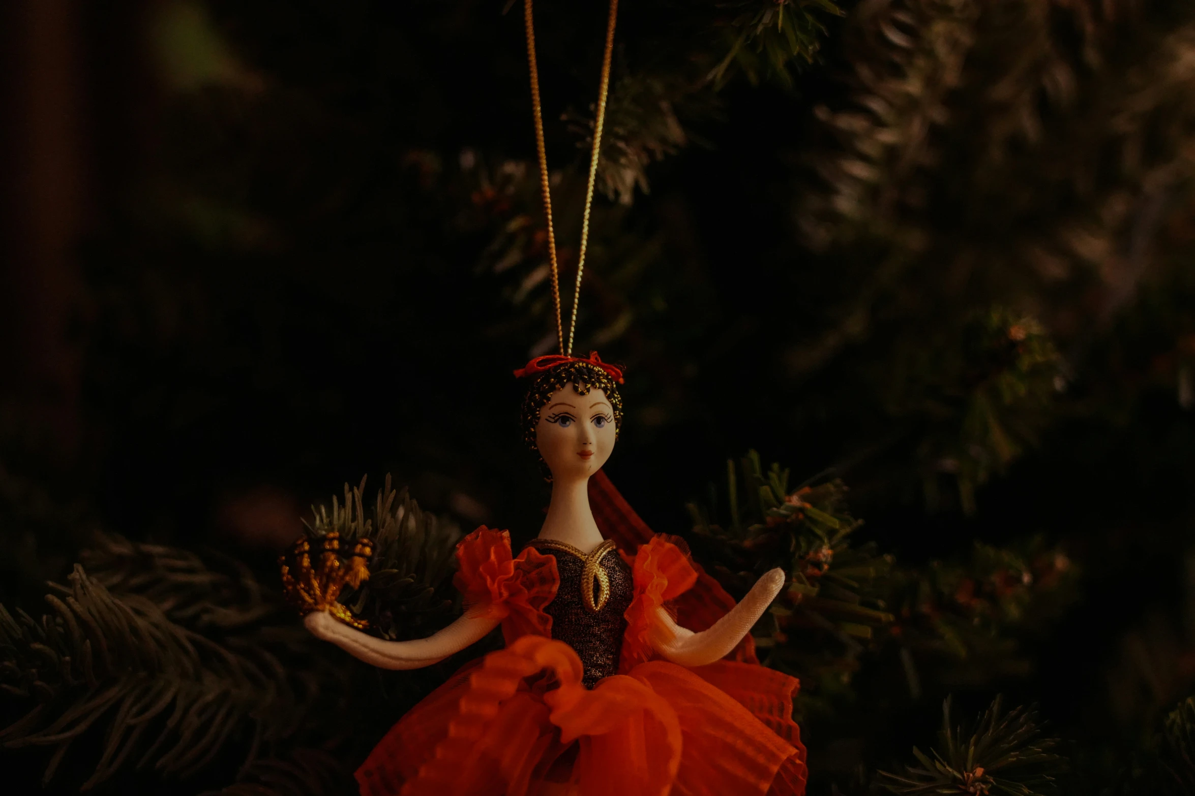 the doll is dressed in red and orange