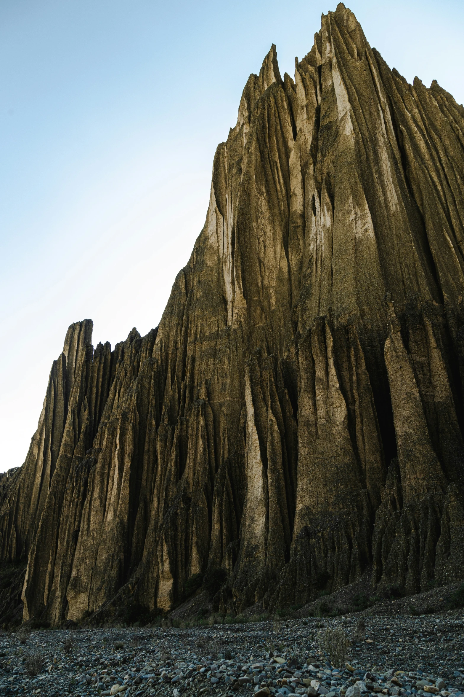 a large rocky mountain towering above the ocean