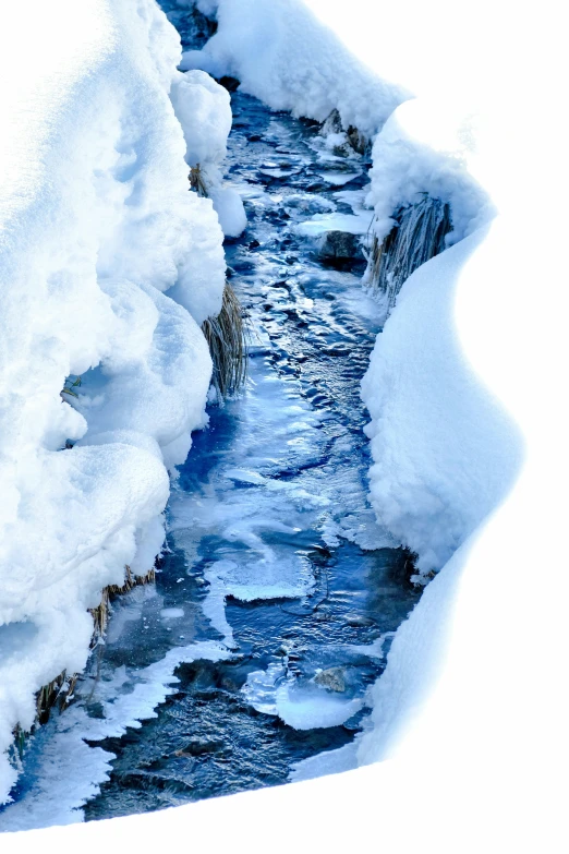 a small stream runs between snow and ice
