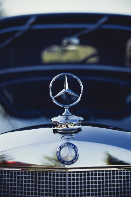the mercedes emblem on the hood of a vintage car