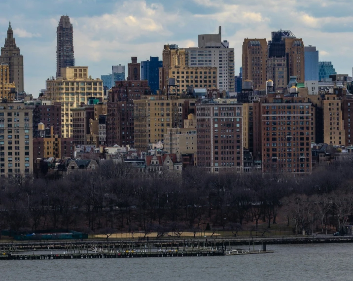 some big buildings are sitting beside the water