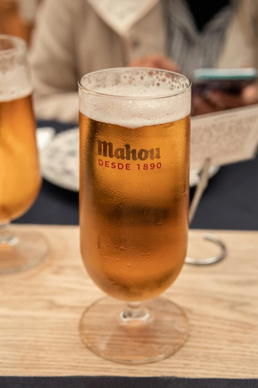 glasses of beer sitting on a table and a person