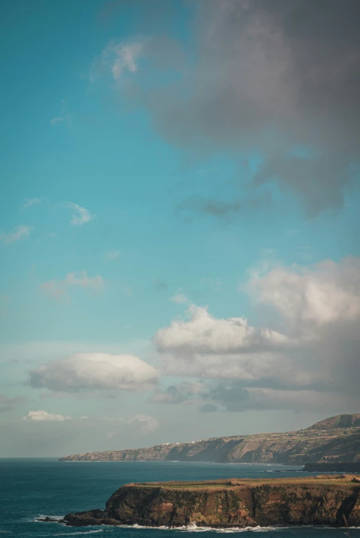 a blue sky over the ocean and a hill