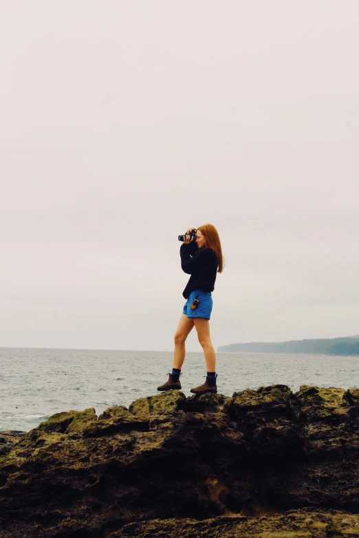 a woman taking pos in front of the water