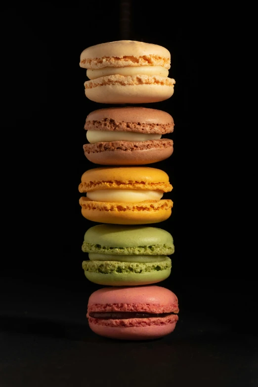 a stack of different colors of macaroons