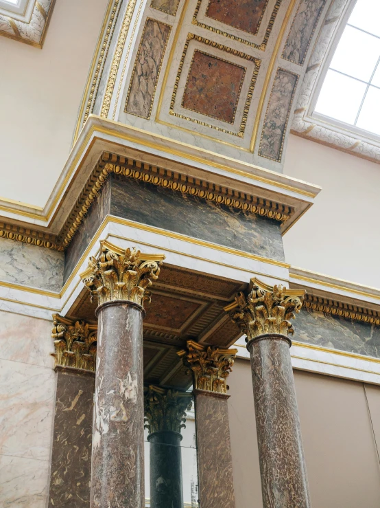 an empty room with columns and gold accents