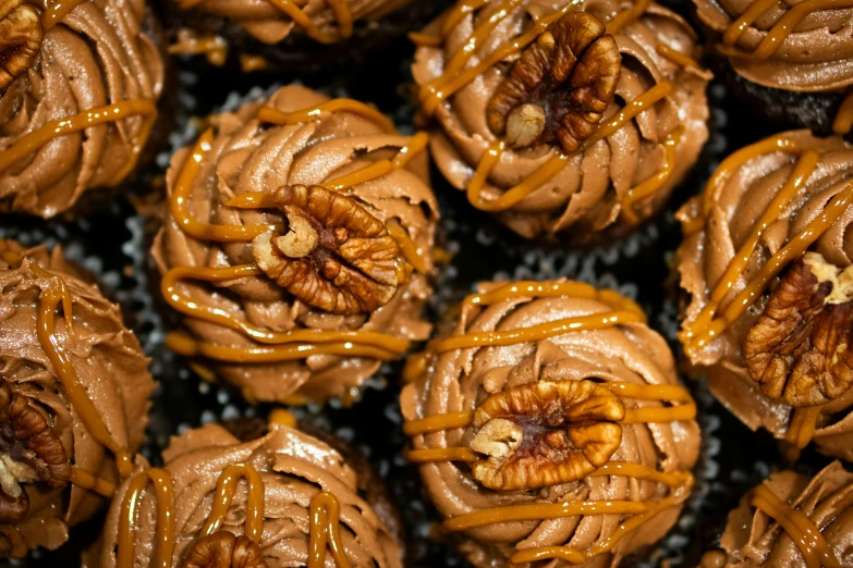 a close up of chocolate cupcakes covered in caramel swirls