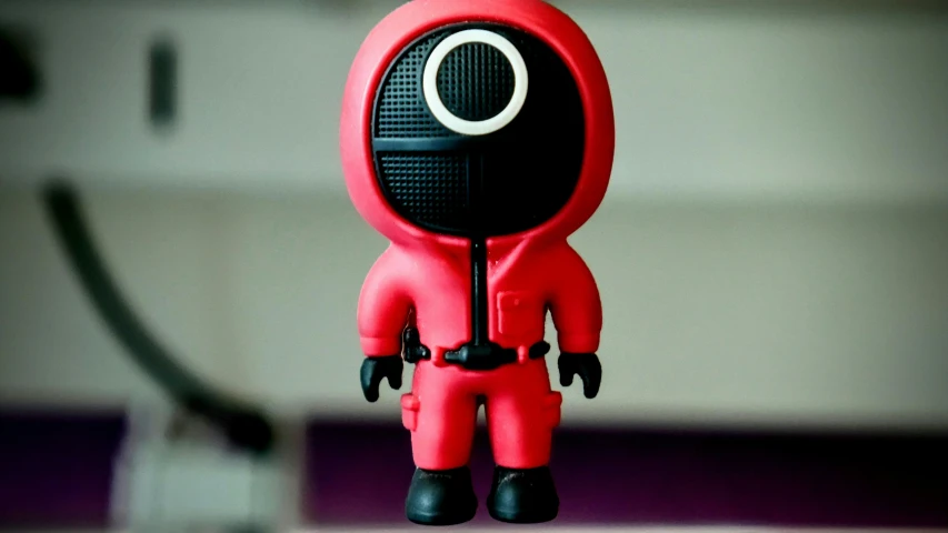 a red object with a black eye and a white background