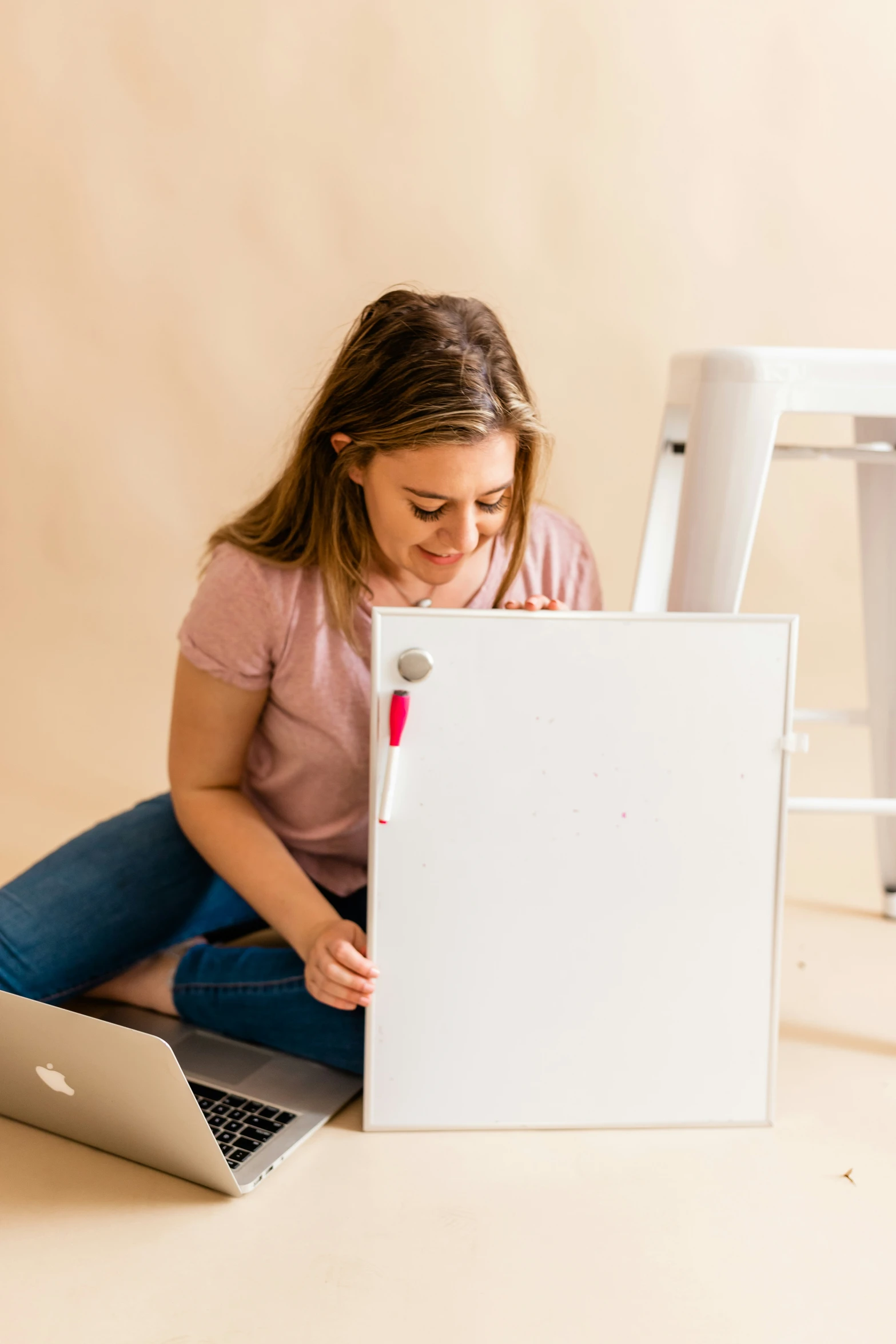 woman sitting in front of white laptop on the floor