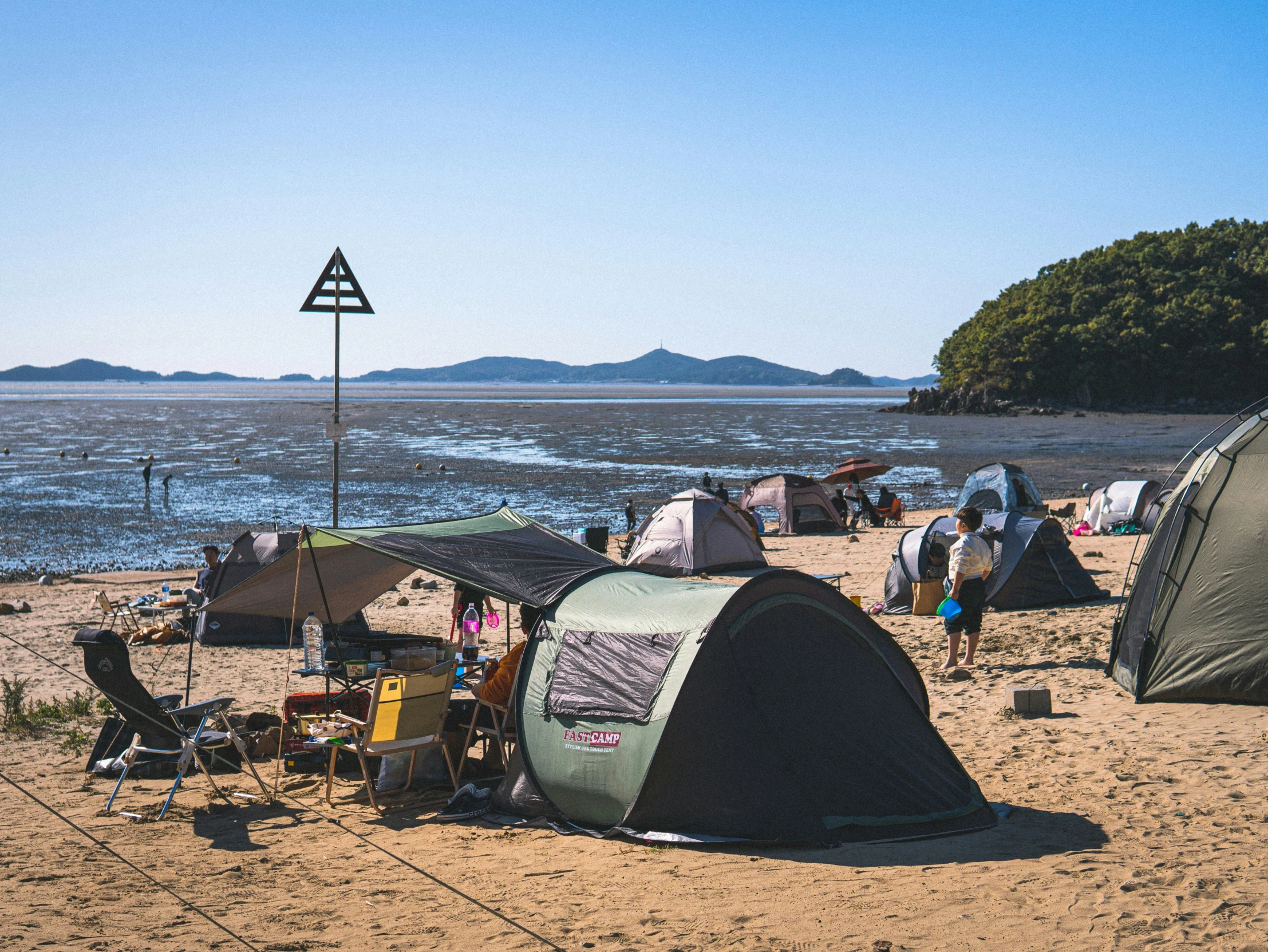 many tents set up along the edge of a lake