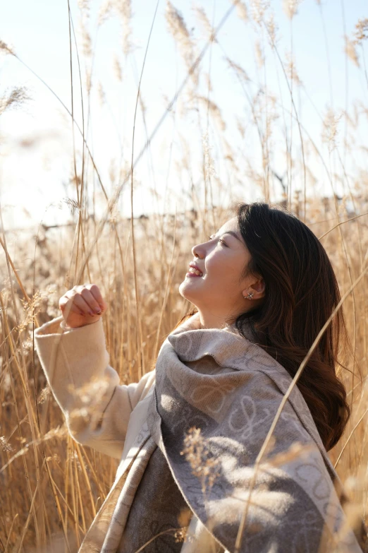 a woman in a hooded jacket in a field of tall grass