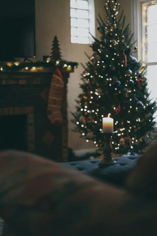 a lighted christmas tree in a bedroom next to a window