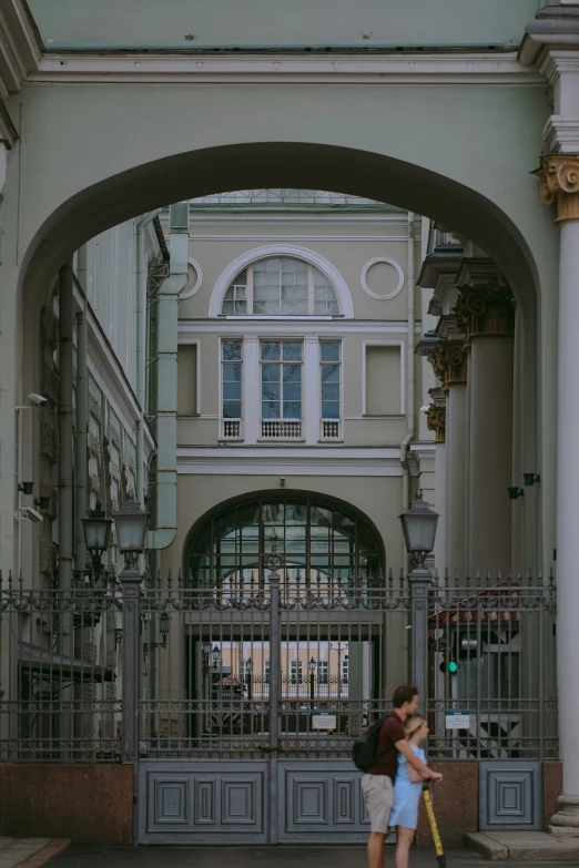 people stand at an entrance to the building with many windows