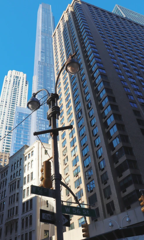 tall buildings rise over a street with traffic lights and signs