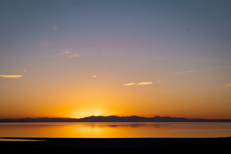 a boat is floating in the water at sunset