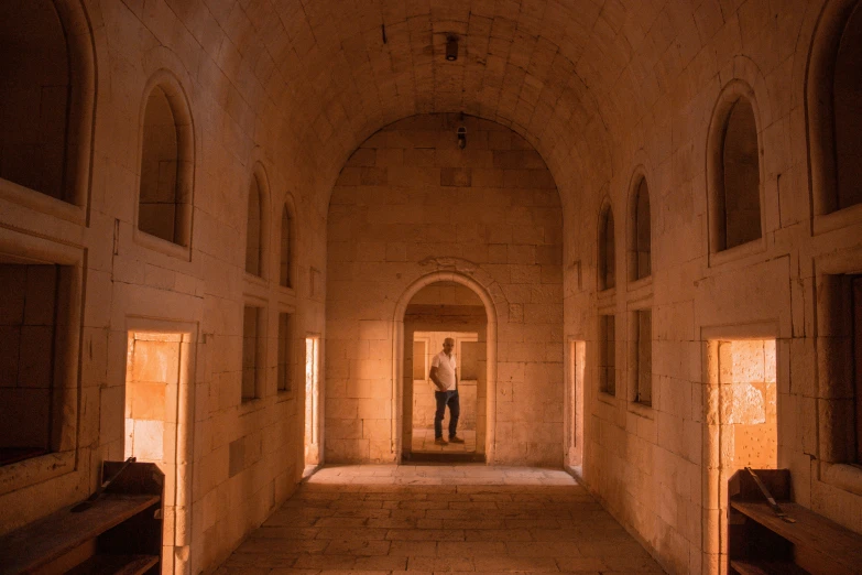 a long corridor with white walls and several windows