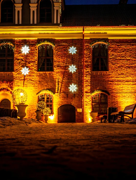 snowflakes and christmas lights decorate the front of a brick building